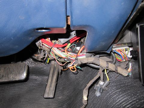 1991 Ford LTD Crown Victoria - A complex bundle of wires and electrical connectors are visible beneath the dashboard of a vehicle.