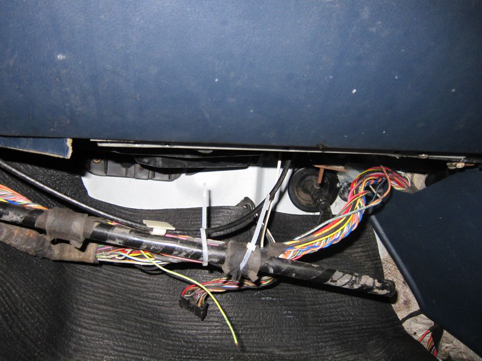 Close-up of a tangled vehicle wiring harness with many colored wires and black zip ties