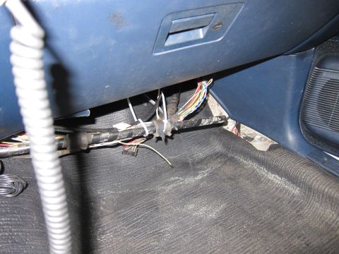 1991 Ford LTD Crown Victoria - Close-up of messy wiring harness secured with zip ties beneath the dashboard of a vehicle.