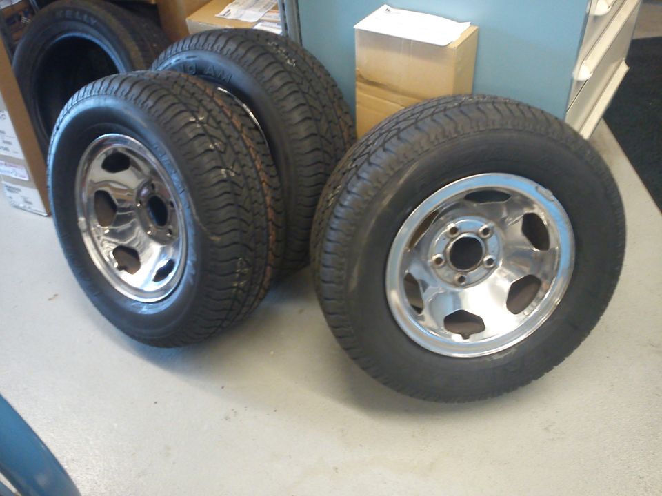 Four chrome wheels with tires, one in foreground