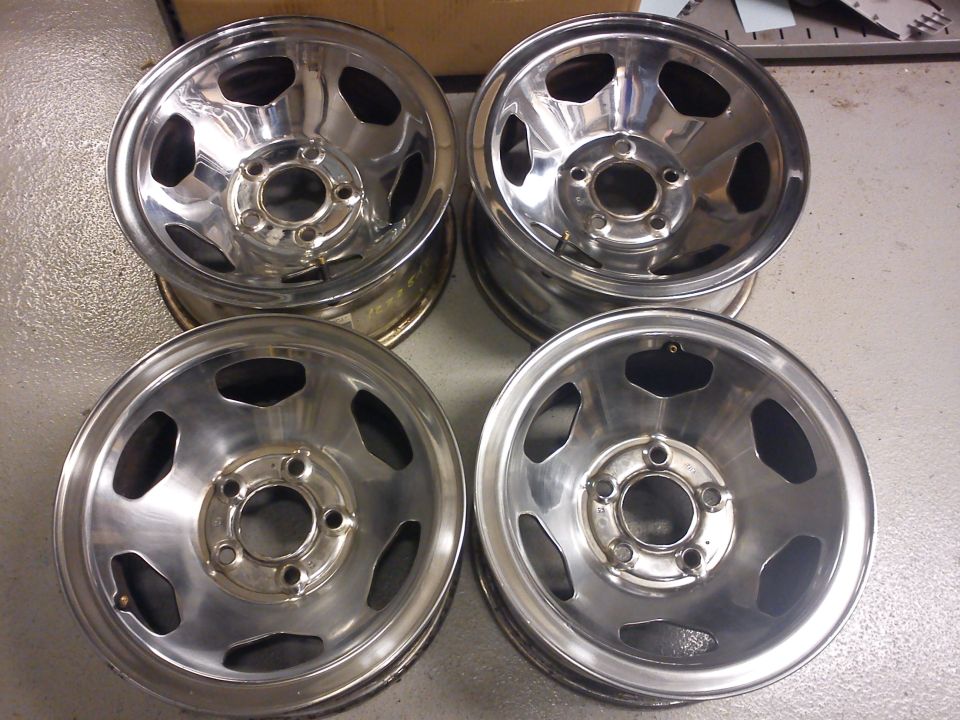 Four chrome wheels with five lug holes each, stacked in pairs