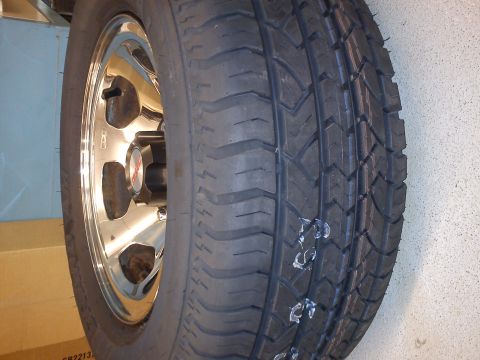 1997 Chevrolet Silverado 1500 - A close-up view of a tire mounted on a shiny chrome wheel, with white markings on the tread.