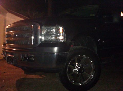 2006 Ford F-350 - Front corner view of a black Ford Super Duty truck, a chrome grille and headlights. The year appears to be 2005.