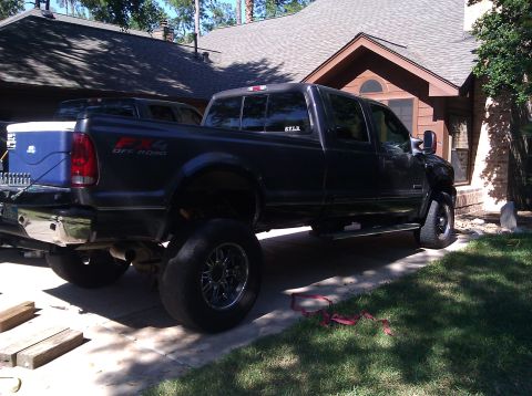 2006 Ford F-350 - Side view of a lifted dark gray Ford F-350 pickup truck parked in a driveway.