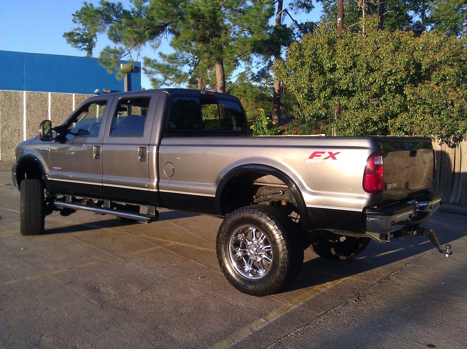 2006 Ford F-350 pickup truck, lifted with chrome wheels, seen from the rear 3/4 angle