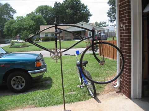 1994 Ford Bronco - A bicycle frame is mounted on a stand in front of a teal pickup truck.