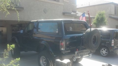 1995 Ford Bronco - A black 1992 Ford Bronco is parked in a driveway with a spare tire on the rear.