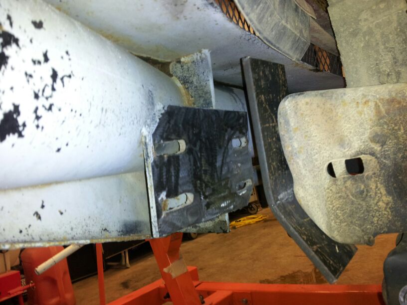 Close-up of a metal bracket attached to a white pipe, likely part of a truck's bumper assembly