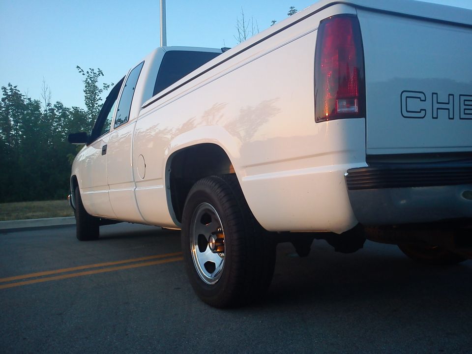 White pickup truck rear quarter view, showing the bed and taillight. The word CHEV is visible on the tailgate