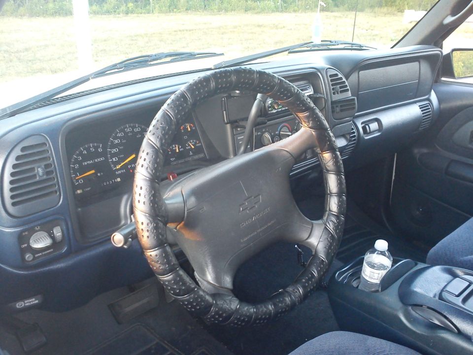 1997 Chevrolet Silverado 1500 interior showing dashboard, steering wheel with cover, and center console with water bottle