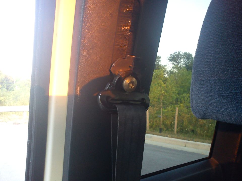 Interior view of a seatbelt mechanism and part of a headrest