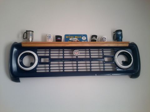 1966 Ford Bronco - A vintage 1966 Ford Bronco grille has been repurposed as a wall-mounted shelf, complete with a Ford badge and a McCoy-Mills sign.