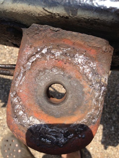 1986 Ford Bronco - A heavily corroded metal bracket, showing signs of welding and wear, is the focus of this image.