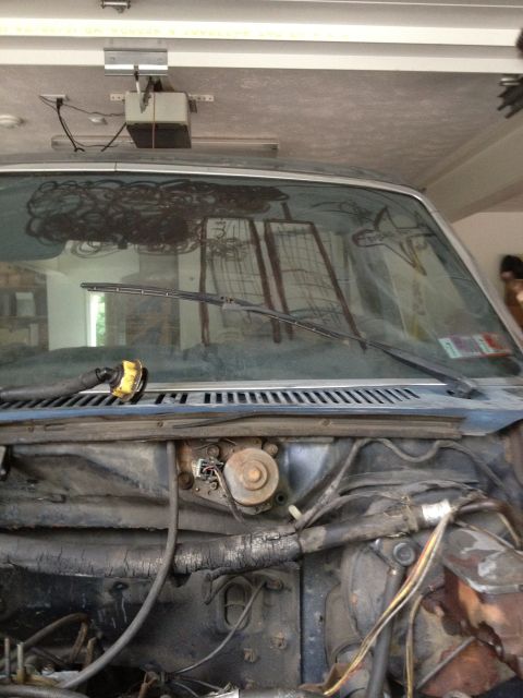 1986 Ford Bronco - Close-up view of a vehicle's windshield and exposed engine bay, likely undergoing maintenance.