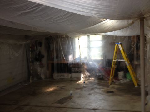 1986 Ford Bronco - This scene shows a room covered in plastic sheeting, likely for painting or renovation, with a ladder and windows visible.