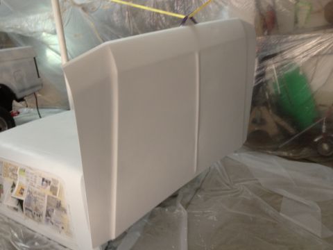 1986 Ford Bronco - A vehicle part is being prepped for paint in a covered booth, with another vehicle visible in the background.