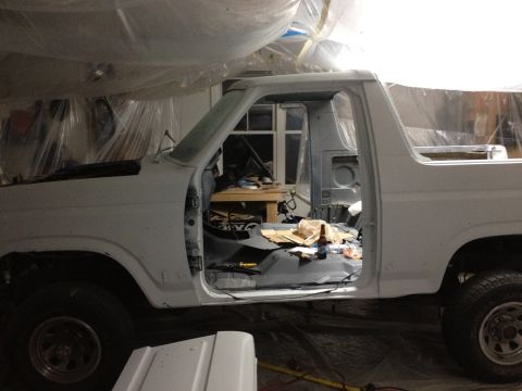 1986 Ford Bronco - This 1986 Ford Bronco is in a garage, likely undergoing restoration or repair, with its doors removed.
