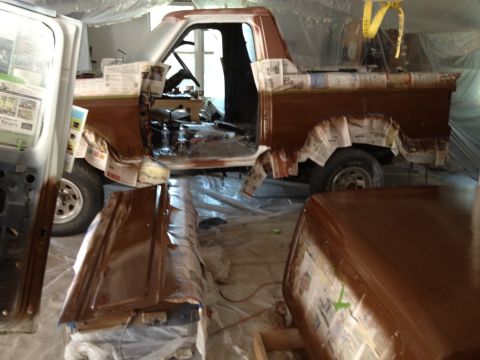 1986 Ford Bronco - This 1986 Ford Bronco is undergoing a rebuild, with parts masked and ready for paint application in a garage setting.