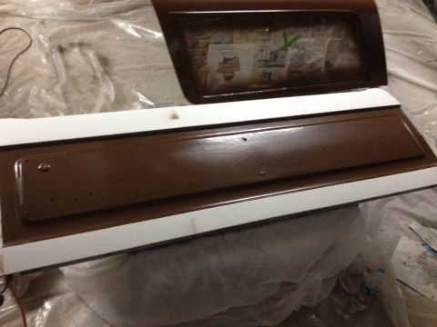 1986 Ford Bronco - A brown and white tailgate and window frame are shown, covered in plastic sheeting, suggesting a restoration or repair process.