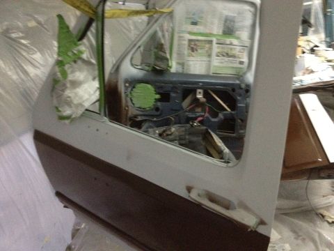 1986 Ford Bronco - The interior of a vehicle door is exposed, revealing wiring and internal mechanisms during a repair or restoration process.
