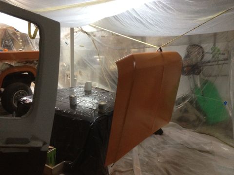 1986 Ford Bronco - Vehicle body and hood are prepped for paint inside a makeshift spray booth.