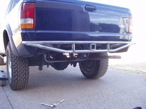 1993 Ford Bronco - The rear of a blue Ford Ranger pickup truck is shown, a custom-built metal bumper with a trailer hitch.