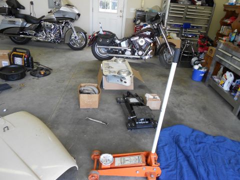 1986 Jeep Wagoneer - Garage scene with motorcycles, a car hood, and various tools including a floor jack.