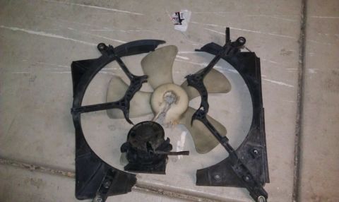 1989 Ford Bronco - Radiator fan assembly is broken, showing damage to the shroud and motor.