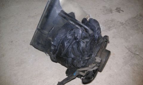 1989 Ford Bronco - A damaged vehicle component sits on a concrete surface, showing signs of significant wear and tear.
