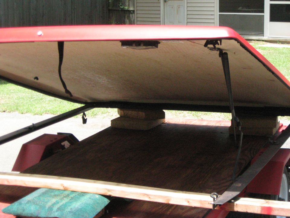 Trailer with red lid open, showing wooden deck and support blocks