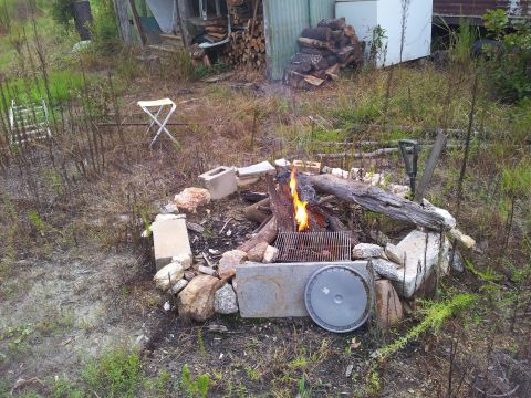 1986 Ford Bronco - Outdoor campfire scene with a grill and a hubcap nearby.