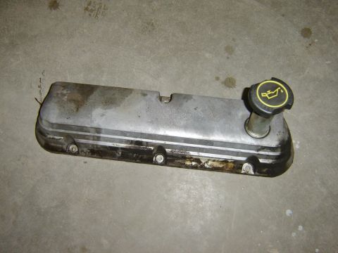 1984 Ford Mustang - Engine valve cover and oil cap on a concrete floor.