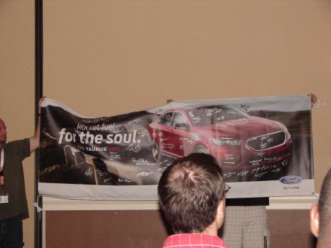 1992 Ford Taurus - A banner displays a red Ford Taurus with numerous signatures, likely from an event.
