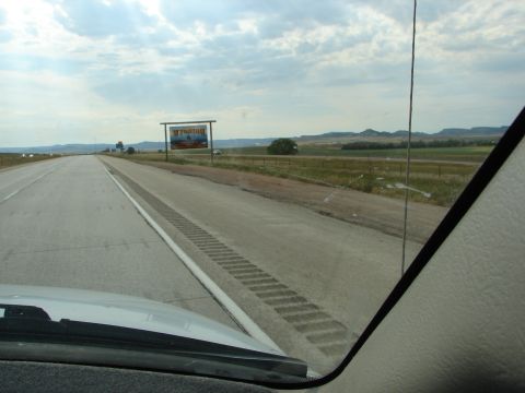 1992 Ford Taurus - Driving on a highway with a Wyoming welcome sign and rolling hills in the background.