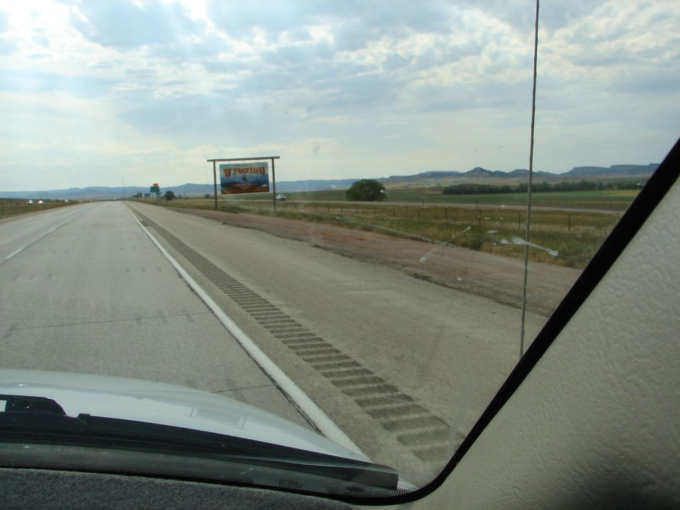 Highway driving through Wyoming with a welcome sign visible