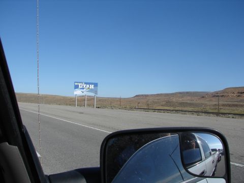 1992 Ford Taurus - Driving into Utah, reflected in the side mirror is a white truck and the "Welcome to Utah" sign.