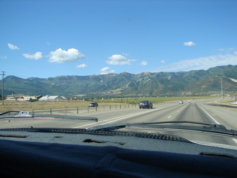driving on highway toward mountains, cars on road