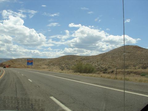 1992 Ford Taurus - Driving past the Arizona state line sign on a sunny day with a vast sky.