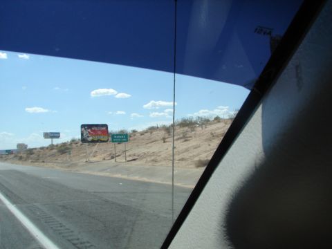 1992 Ford Taurus - View from inside a vehicle shows roadside signs indicating the Nevada state line under a bright, cloudy sky.