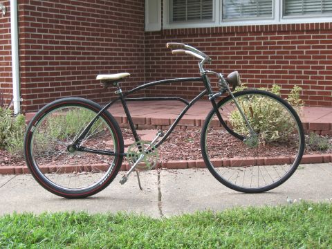 1994 Ford Bronco - A vintage-style bicycle is parked on a sidewalk in front of a brick house.