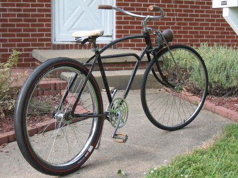 1994 Ford Bronco - A classic bicycle with a sprung seat and a headlight sits outside a brick house.