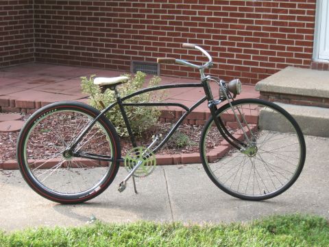 1994 Ford Bronco - A vintage-style bicycle with a black frame and white saddle sits on a sidewalk.