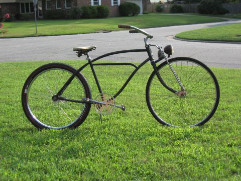 1994 Ford Bronco - A black vintage bicycle with a headlight and a gold chainring is parked on a grassy lawn.