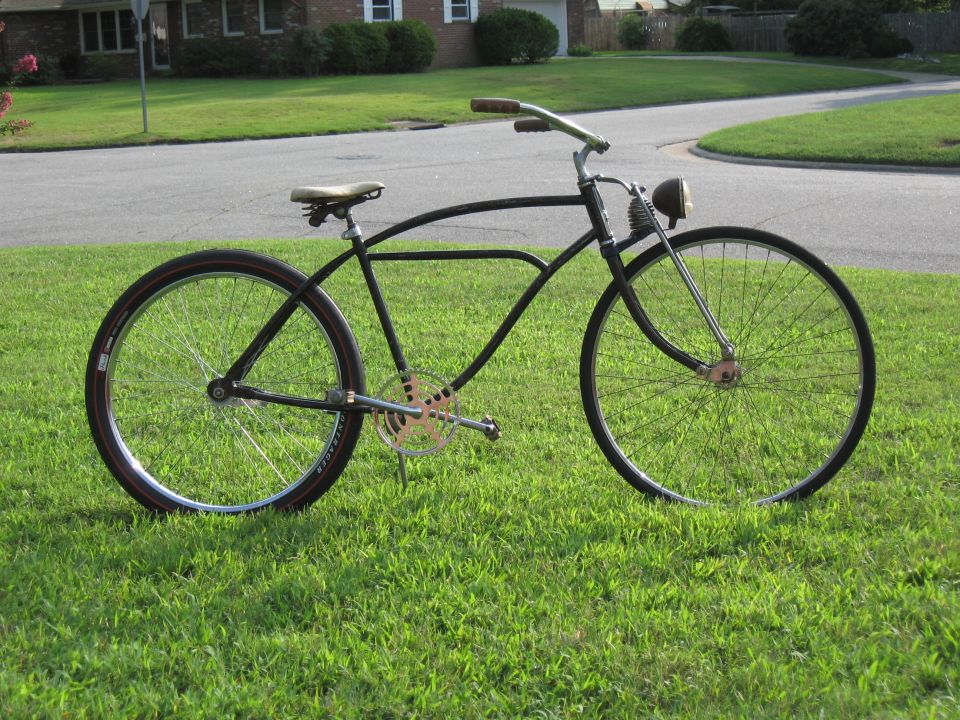 Black vintage bicycle side view with a headlight and gold chainring