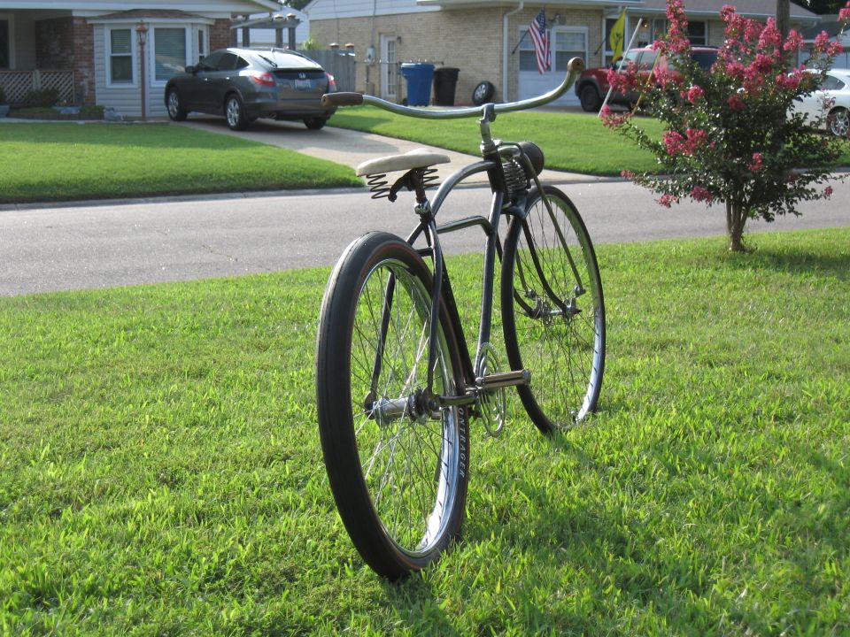 Vintage bicycle parked on a grassy lawn in front of a suburban house