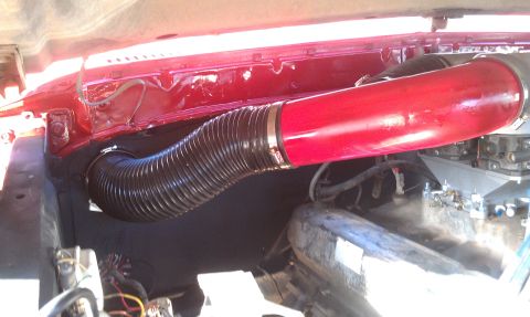1978 Ford Bronco - Close-up of engine bay components, including a red intake tube and flexible hose.