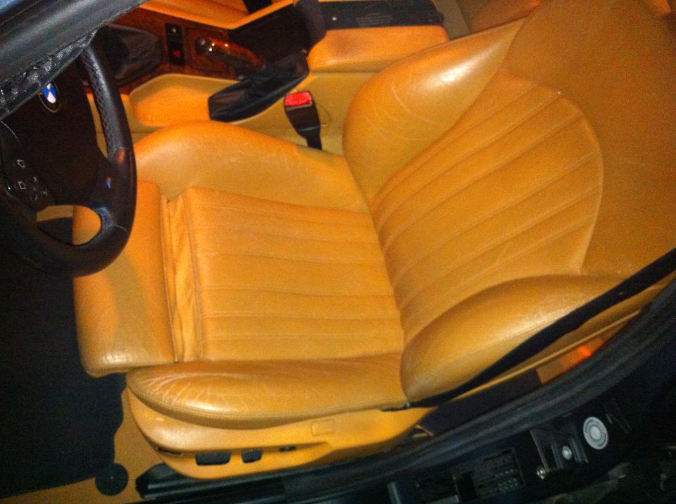 Tan leather interior of a 2000 BMW M5, showing the driver's seat and dashboard details