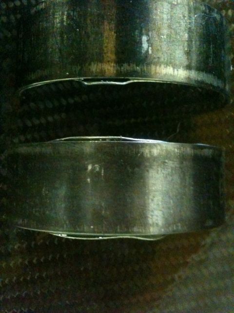 1965 Ford Fairlane - Close-up view of two engine bearings, likely showing signs of wear and tear.