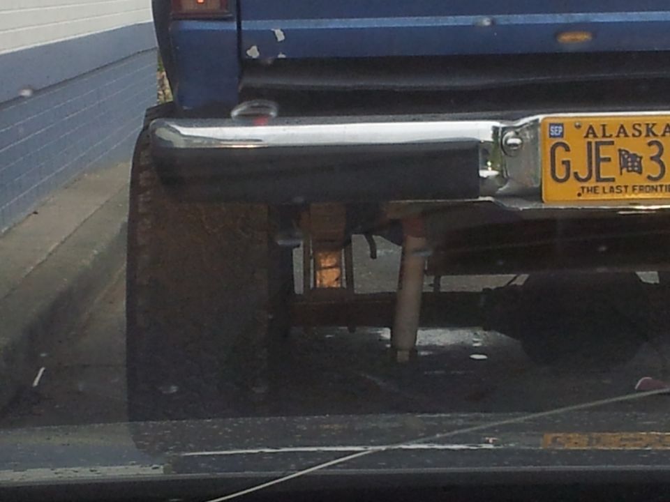 Alaska license plate GJE 3 on blue vehicle's rear bumper