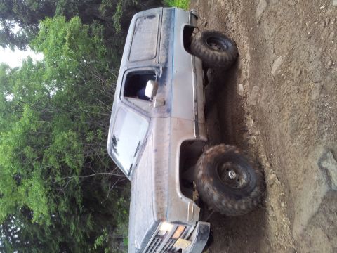 1990 Chevrolet Suburban - This Chevrolet K5 Blazer is shown off-road on a dirt path with trees in the background.